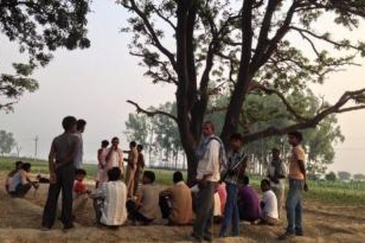 Warga berkumpul di sebuah pohon di distrik Badaun, Uttar Pradesh, India. Pohon inilah yang menjadi tempat menggantung dua orang gadis belia yang diduga telah diperkosa. 