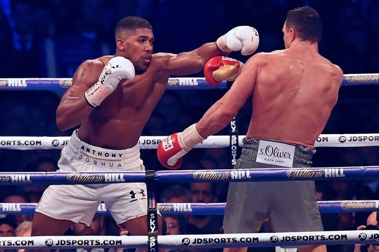 Petinju Inggris, Anthony Joshua (kiri), melancarkan pukulan ke arah petinju asal Ukraina, Wladimir Klistchko, dalam pertarungan kelas berat di Stadion Wembley, London, Sabtu (29/4/2017) waktu setempat.