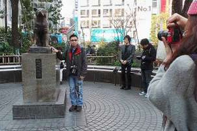 Seorang wisatawan berfoto di samping patung anjing Hachiko di dekat Stasiun Shibuya, Tokyo, Jepang.