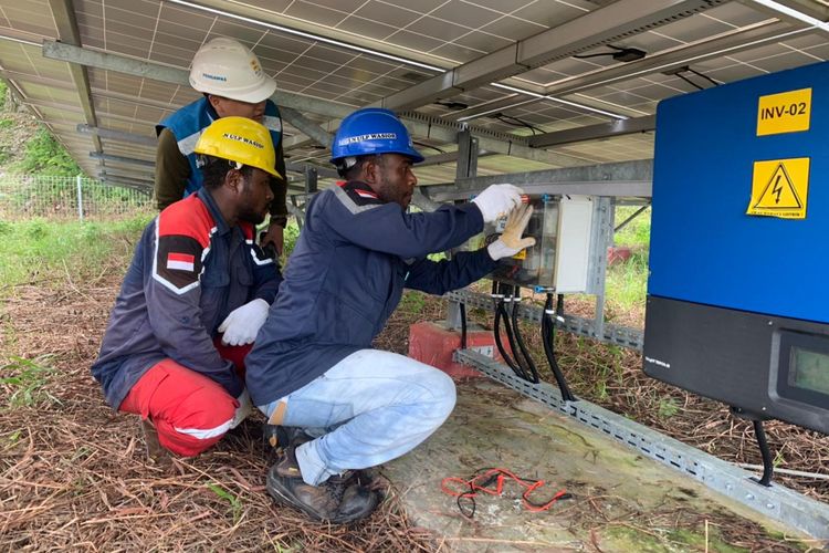 Petugas PLN saat melakukan pemasangan jaringan listrik PLTS di Teluk Wondama