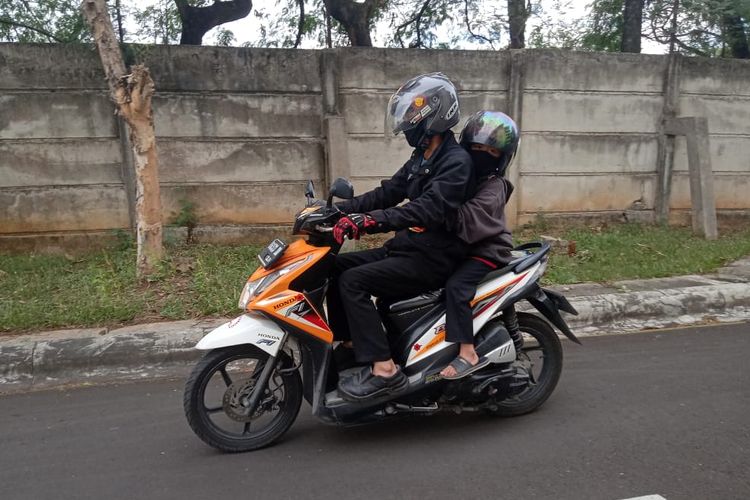 Ilustrasi bonceng anak dengan aman di motor.