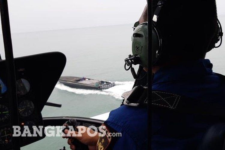 Petugas Ditpolairud Polda Kepulauan Bangka Belitung saat meminta kapal hantu menghentikan laju kapal ketika dilakukan pengejaran dari atas helikopter.
