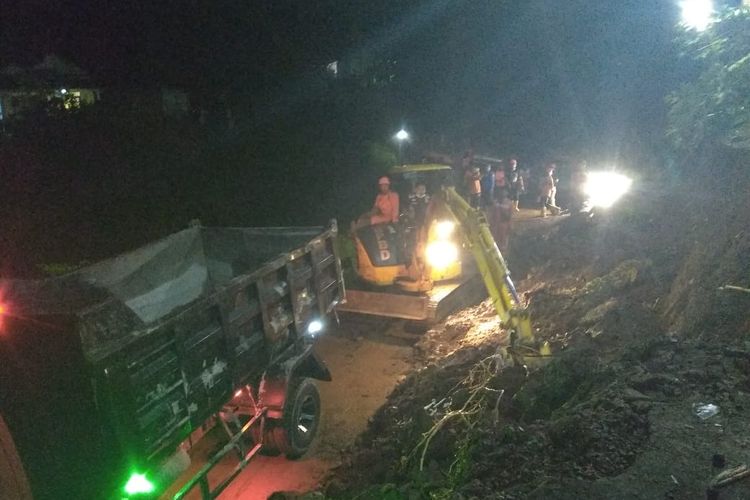 Personel BPBD Kabupaten Semarang membersihkan material longsor yang menutup akses jalan.