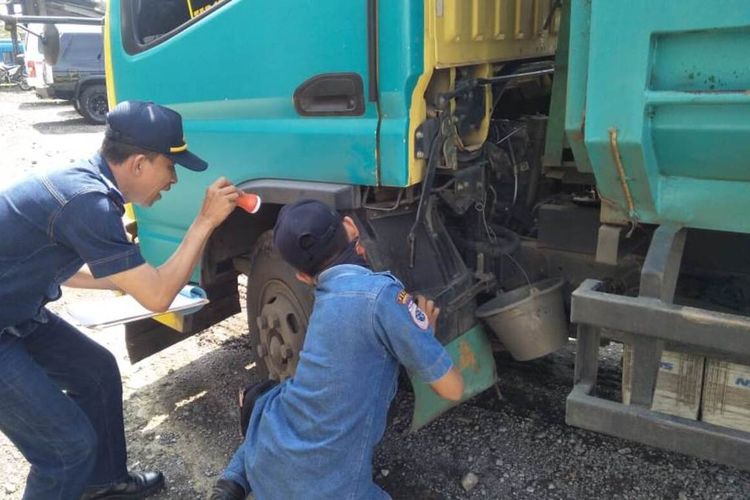 Petugas tengah memeriksa kelaikan kendaraan saat melakukan ram check di ruas jalan raya Cianjur-Sukabumi, Gekbrong, Cianjur, Jawa Barat, Jumat (20/12/2019)