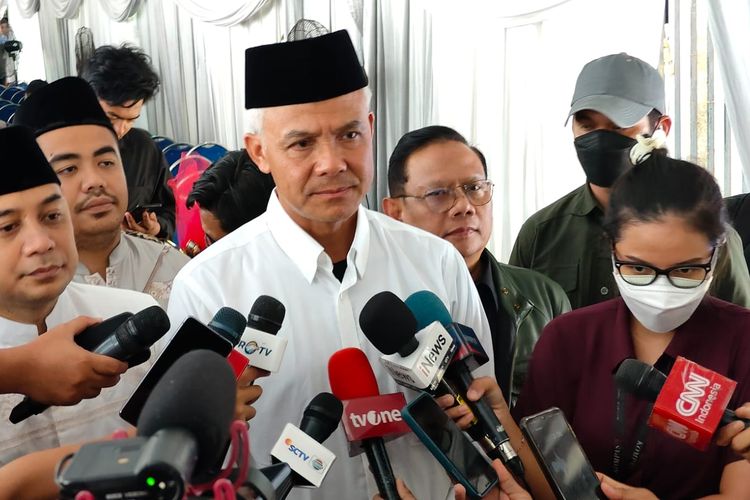 Calon presiden nomor urut 3 Ganjar Pranowo (tengah) didampingi Wali Kota Surabaya Eri Cahyadi (kiri) usai menghadiri haul ayah Eri, di Surabaya, Jawa Timur, Sabtu (13/1/2024).