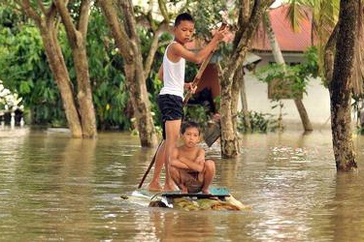 Anak-anak melintasi banjir dengan menggunakan rakit di Serdang Bedagai, Sumatera Utara, Selasa (6/11/2012).