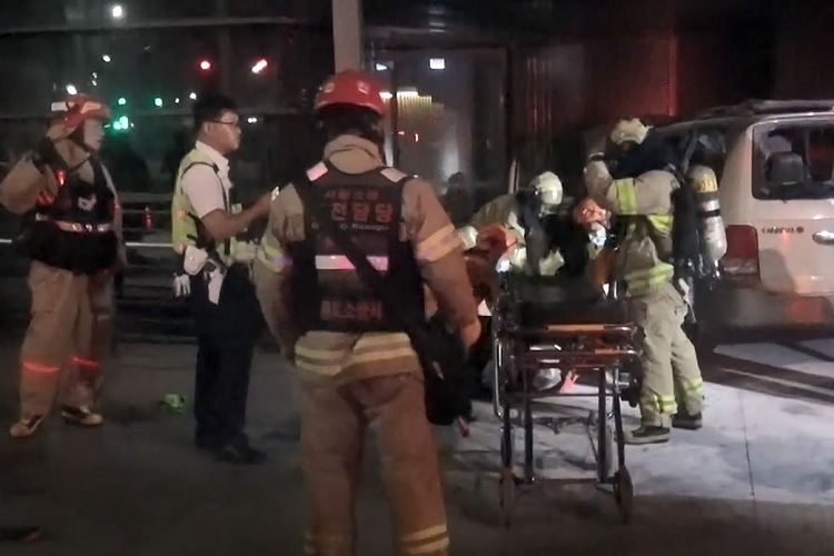 Foto yang dirilis Departemen Pemadam Kebakaran Jongro, menunjukkan saat petugas pemadam kebakaran mengangkut pria Korea Selatan yang melakukan aksi bakar diri di depan Kedubes Jepang di Seoul, Jumat (19/7/2019), ke rumah sakit.