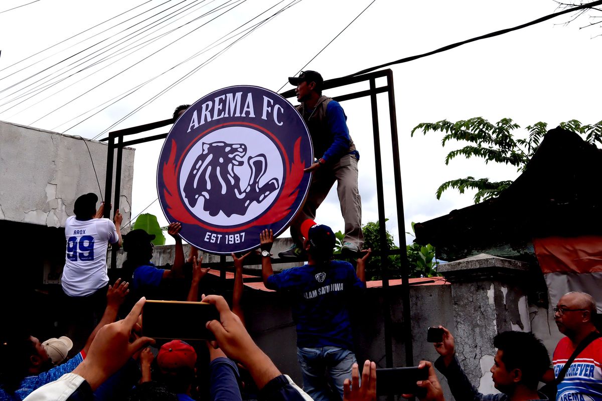 Sejumlah Aremania memasang logo yang telah dibakar seusai rapat kordinasi di samping Official Arema FC Store, Selasa (31/1/2022) sore.