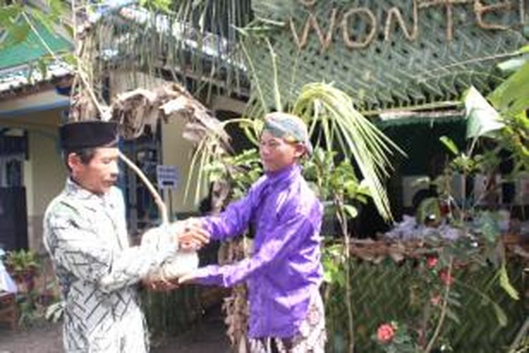 Petugas PPS di TPS 13 Dusun Grogolan, Desa Dukun, Kecamatan Dukun, Kabupaten Magelang memberi bebungah (hadiah) berupa bibit tanaman kepada warga yang telah mencoblos di bilik suara, Rabu (9/4/2014).