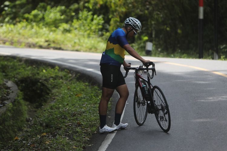 Peserta Cycling De Jabar yang berhenti sesaat untuk mengambil nafas ketika melalui jalur menanjak di Ciletuh, Sukabumi, Jawa Barat, Sabtu (27/8/2022).