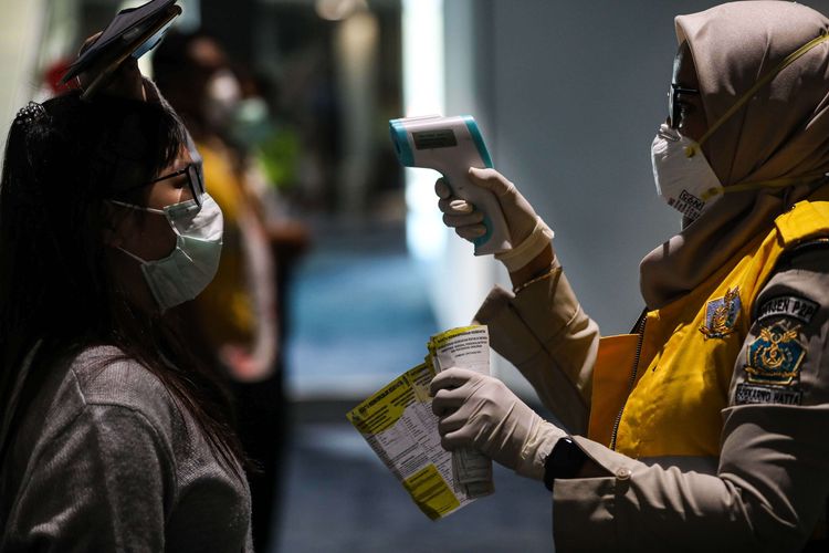 Petugas Kantor Kesehatan Pelabuhan (KKP) bandara Soekarno-Hatta  memeriksa suhu tubuh wisatawan asal China yang baru mendarat di Terminal 3 Bandara Soekarno-Hatta, Selasa (28/1/2020). Saat ini ada sekitar 40.000 penumpang keberangkatan dan kedatangan internasional yang hilir mudik ke Bandara Soekarno-Hatta. Data terakhir mencatat wabah Corona sudah menjangkiti 4.500 orang dan menewaskan 106 orang di China.