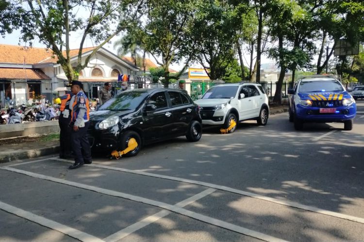 Puluhan kendaraan baik roda dua maupun roda empat digembok petugas akibat parkir sembarangan di jalanan Kota Cimahi, Jawa Barat, Selasa (11/7/2023).