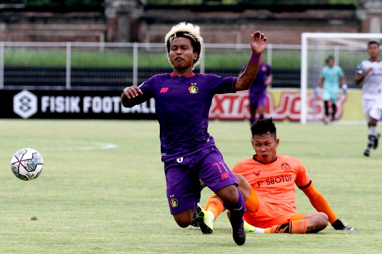 Pemain Persik Kediri Fahmi Al-Ayyubi dihalau kiper Persikabo 1973 Syahrul Trisna pada pertandingan pekan 19 Liga 1 2021-2022 yang berakhir dengan skor 1-2 di Stadion I Gusti Ngurah Rai Denpasar, Jumat (14/1/2022) malam.