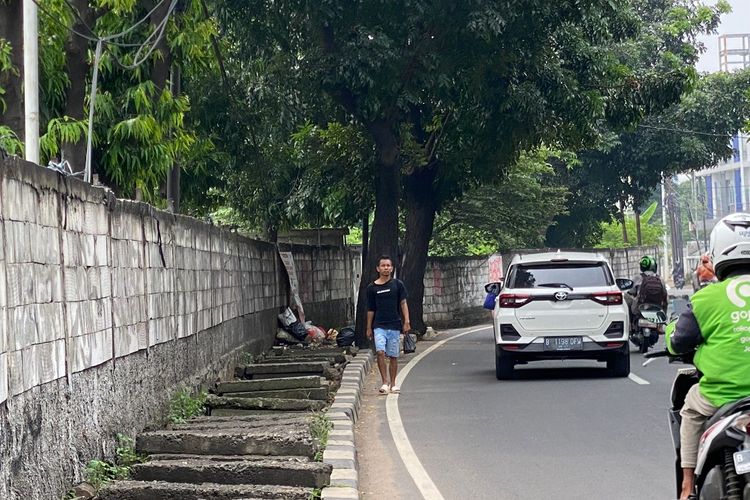 Seorang pejalan kaki berjalan di bahu Jalan Lenteng Agung Raya karena trotoar mengalami kerusakan, Rabu (3/4/2024).