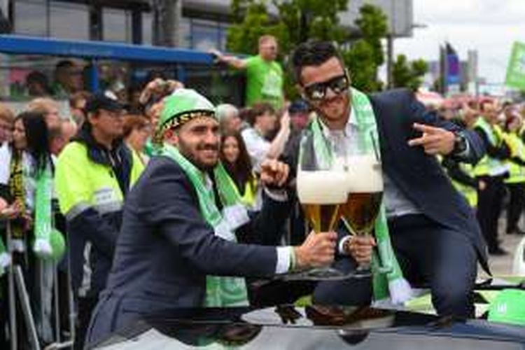 Dua pemain Wolfsburg, Daniel Caligiuri (kiri) dan Vierinha, berpose dengan gelas bir saat merayakan kesuksesan menjuarai DFB Pokal, 31 Mei 2015.