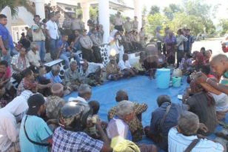 Demo tuntut Bupati Timor Tengah Utara (TTU), Nusa Tenggara Timur (NTT), segera cabut izin tambang mangan milik perusahaan Elgary Resources Indonesia, warga makan pisang dan jagung Bose di depan kantor Bupati, Kamis (21/5/2015)