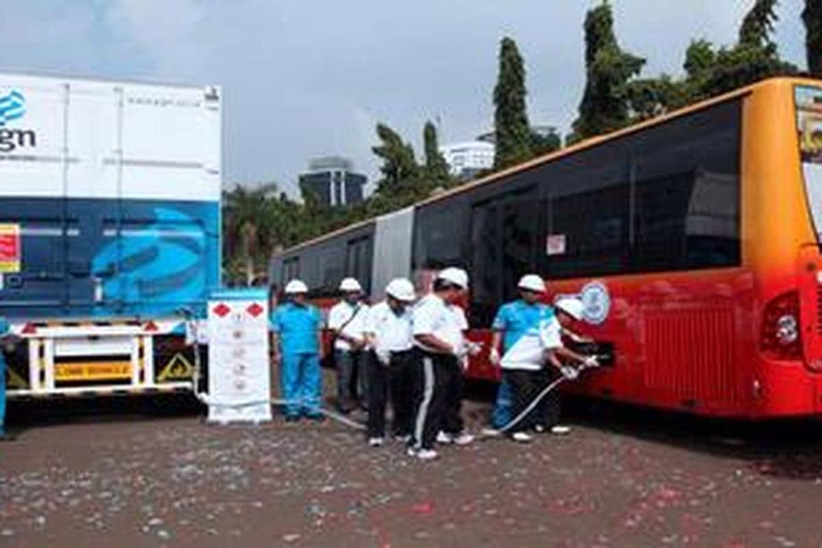 Didampingi Dirut Perusahaan Gas Negara, Hendi Prio Santoso, Menteri Energi dan Sumber Daya Mineral, Jero Wacik, mengisi bahan bakar gas ke armada transjakarta dari Mobile Refueling Unit (MRU) yang diresmikan penggunaannya di Monumen Nasional, Jakarta Pusat, Minggu (19/5/2013). Pengoperasian fasilitas pengisian bahan bakar gas bergerak ini untuk menyiasati kendala pembangunan SPBG  yaitu ketersediaan lahan.