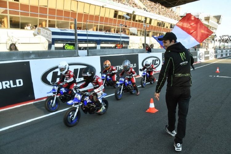 Pebalap Monster Yamaha Tech 3, Johann Zarco, mengibarkan bendera Perancis di sela-sela latihan bebas MotoGP di Le Mans, 19 Mei 2018. 