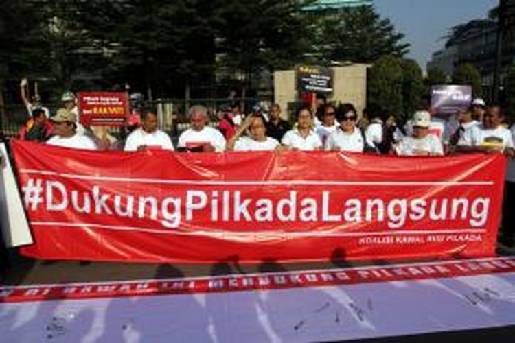 Aktivis yang tergabung dalam Koalisi Kawal RUU Pilkada melakukan aksi damai dan pengumpulan tanda tangan dari warga yang sedang menikmati car free day di sekitar bundaran HI Jakarta Pusat, Minggu (14/9/2014). Mereka mengajak warga untuk menolak RUU Pilkada yang menghilangkan Pilkada langsung selain itu mengembalikan Pilkada kepada DPRD berarti kemunduran dalam partisipasi politik rakyat dan demokrasi substansial.