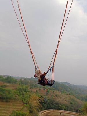 Seorang pengunjung tengah mencoba ayunan raksasa, Giant Swing.