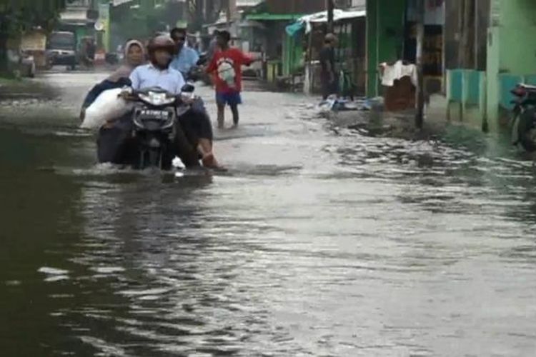 Banjir yang masih menyisakan genangan air di sejumlah jalan dan permukiman di Kecamatam Bangil Kab. Pasuruan usai hujan deras yang menyebabkan Sungai Kedunglarangan dan Sungai Wrati meluap.