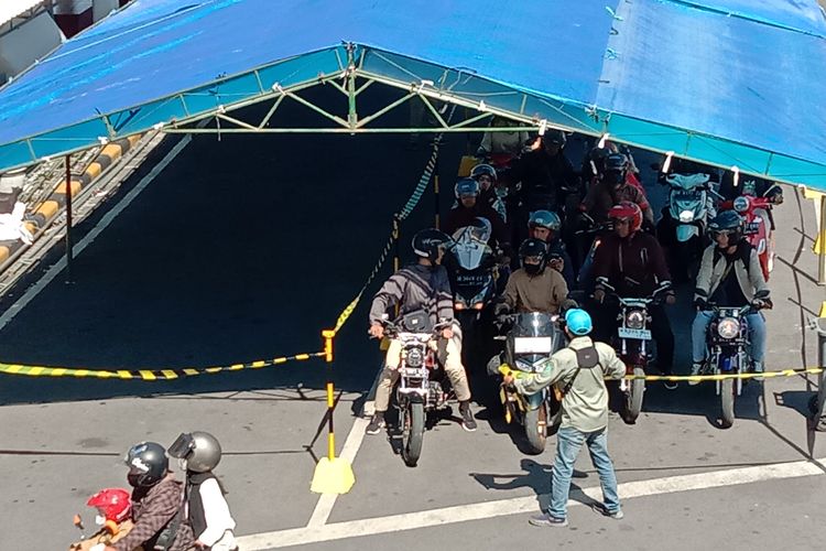 Pengendara motor saat menunggu di tenda antrean Pelabuhan ASDP Ketapang Banyuwangi 