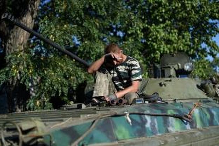 Seorang anggota milisi separatis pro-Rusia sedang beristirahat di atas sebuah tank T-64 dia Starobesheve, sebelah tenggara kota Donetsk saat mempersiapkan sebuah serangan baru terhadap sebuah lokasi penting di pesisir timur Ukraina, Minggu (31/8/2014).