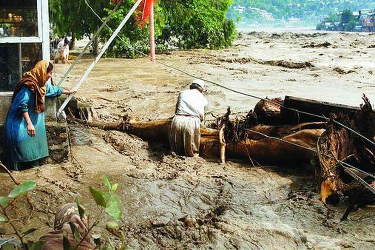 Warga desa Pakistan mencoba menghalangi pohon-pohon yang hanyut terbawa air bah di Sungai Nelum, Muzaffarabad, ibu kota Kashmir Pakistan, Jumat (30/7). Korban tewas akibat banjir Pakistan melebihi jumlah 300 jiwa selama tiga hari.