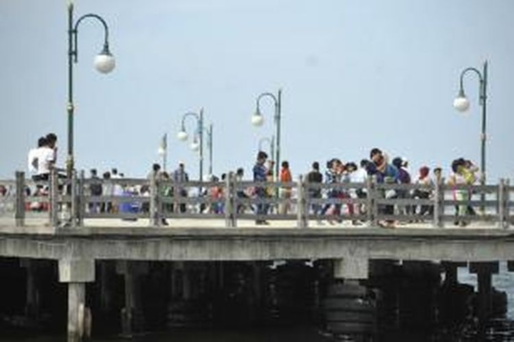 Pengujung menikmati pemandangan lepas pantai dari Dermaga Pantai Festival, Taman Impian Jaya Ancol, Jakarta Utara, Minggu (21/4/2013). Kawasan tersebut menjadi salah tempat pilihan warga Jakarta dan luar Jakarta yang ingin berwisata menikmati suasana pantai dengan nyaman. 