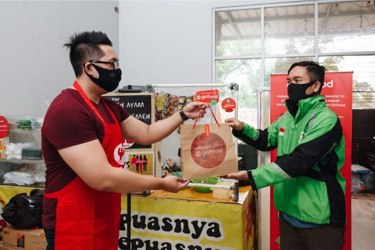 Ilustrasi mitra GoFood sedang mengambil pesanan konsumen. 