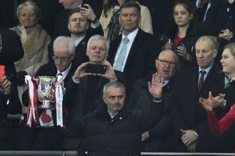 Manajer Manchester United, Jose Mourinho, memegang trofi Piala Liga Inggris setelah timnya menang 3-2 atas Southampton pada laga final yang digelar di Stadion Wembley, Minggu (26/2/2017).  Ini adalah trofi pertama bagi Mourinho sejak menangani Man United pada awal musim. 
