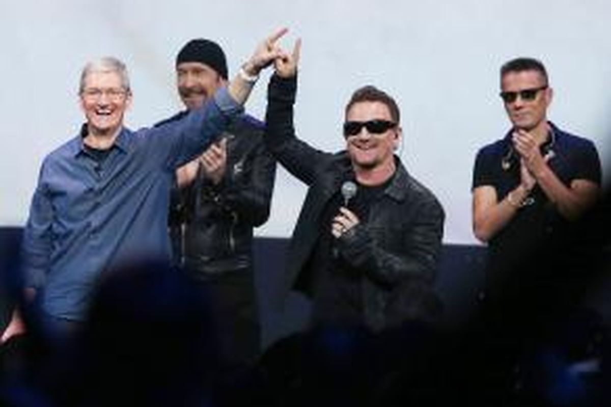 Para personel band rock Irlandia U2, yaitu Bono (kedua dari kanan), The Edge (kedua dari kiri), dan Larry Mullen Jr (paling kanan) berfoto bersama CEO Apple, Tim Cook (paling kiri), di Flint Center, Cupertino, California, AS, dalam acara peluncuran tiga produk terkini perusahaan tersebut, pada 9 September 2014 waktu setempat.