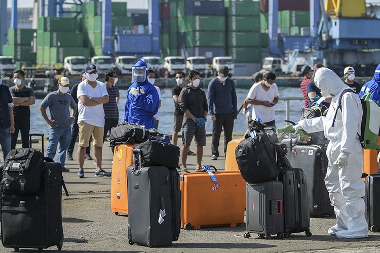 Petugas kesehatan menyemprotkan cairan disinfektan ke atas permukaan barang bawaan milik warga negara Indonesia (WNI) yang menjadi anak buah kapal (ABK) Kapal Pesiar MV Westerdam setibanya di Pelabuhan JICT 2, Tanjung Priok, Jakarta, Selasa (2/6/2020). Sebanyak 679 orang WNI ABK MV Westerdam tersebut akan menjalani serangkaian tes kesehatan sesuai protokol pencegahan Covid-19 seperti tes swab (PCR) sebelum menjalani isolasi mandiri di hotel.