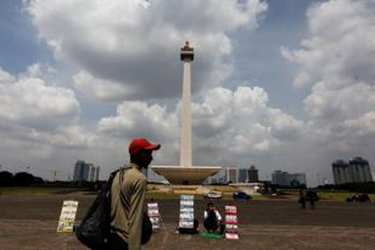 Pedagang minuman dan penjual jasa foto kilat kembali terlihat di pelataran Monumen Nasional (Monas), Jakarta Pusat, Senin (5/5/2014). Larangan untuk berjualan dan membeli dari pedagang di dalam lingkungan Monas belum efektif. Masih banyak pedagang yang menggelar lapaknya di area taman maupun di dalam kompleks Monas.