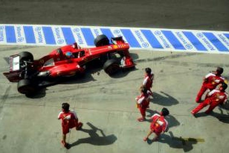 Pebalap Ferrari asal Spanyol, Fernando Alonso tiba di pit saat sesi kualilfikasi GP Italia di Sirkuit Monza, Sabtu (7/9/2013).