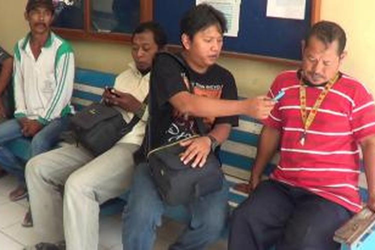 Abdul Rosyid (kaos merah) saat di Mapolsek Brebes, Jawa Tengah, melaporkan kasus hipnotis yang menimpanya sehingga 45 ekor kambing kurban dagangannya raib.