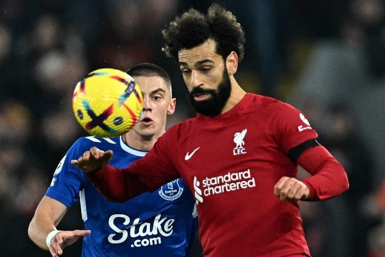 Mohamed Salah berebut bola dengan Vitaliy Mykolenko dalam laga pekan ke-23 Liga Inggris 2022-2023 antara Liverpool vs Everton di Stadion Anfield, Selasa (14/2/2023) dini hari WIB. Otoritas Liga Inggris akan memberi kesempatan kepada pemain Muslim seperti Salah untuk berbuka puasa saat sedang bertanding pada bulan Ramadhan. (Photo by Paul ELLIS / AFP) 