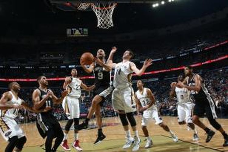 Pebasket San Antonio Spurs, Tony Parker (#9) akan melakuan layup di tengah penjagaan para pemain New Orleans Pelicans pada lanjutan kompetisi NBA di New Orleans, Senin (13/01/2014).