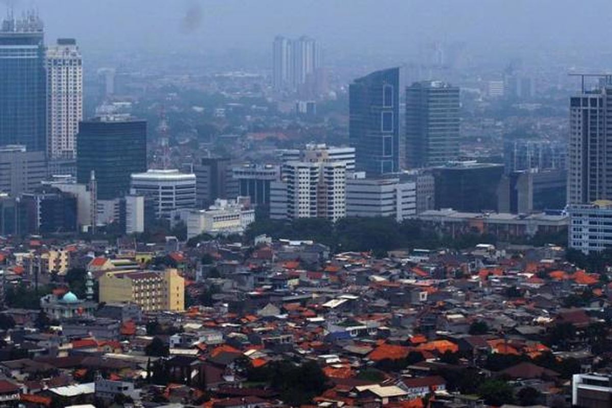 Kepadatan permukiman penduduk berlatar belakang gedung bertingkat terlihat dari ketinggian di Jakarta, Senin (12/12/2011).