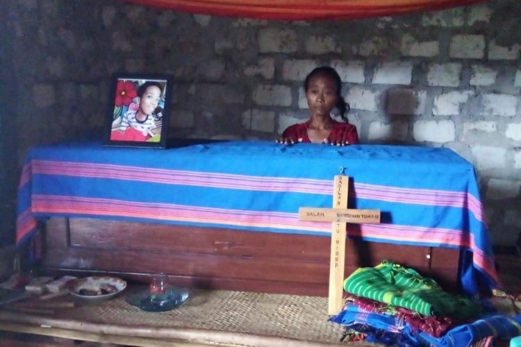 Regina Deta Karere (38) tampak memegang peti jenazah anaknya Dominggus Japa Loka (17) yang disemayamkan di rumah kerabatnya di Kampung Rada Loko, Desa Mali Iha, Kecamatan Kodi, Kabupaten Sumba Barat Daya, Nusa Tenggara Timur, Senin (14/12/2020) siang. 