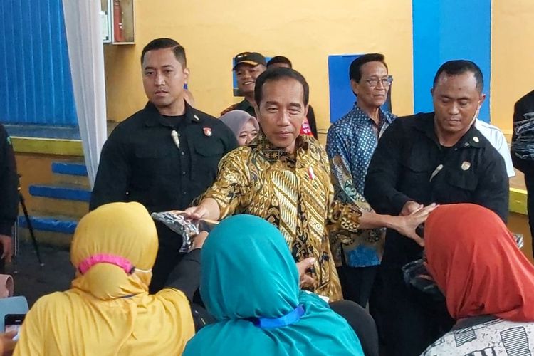 Presiden Joko Widodo membagikan kaos usai pelaksanaan penyaluran bantuan pangan cadangan beras pemerintah di Gudang Bulog, Purwomartani, Kapanewon Kalasan, Kabupaten Sleman