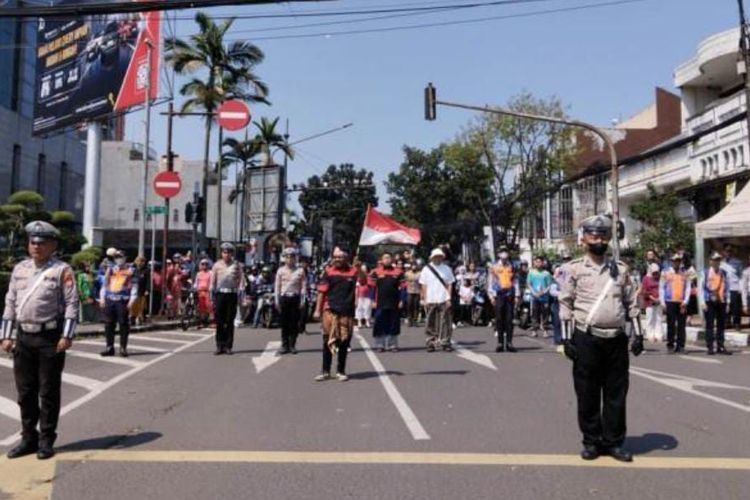 Polisi dan para pengguna jalan turun dari kendaraannya untuk memberikan hormat kepada Bendera Merah Putih saat detik-detik proklamasi. Video ini viral di media sosial dan direpost Dedi Mulyadi. 