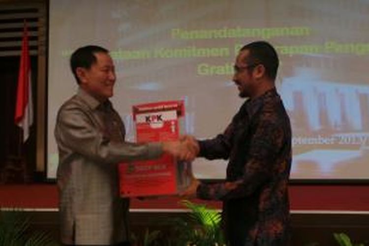 Ketua Komisi Pemberantasan Korupsi (KPK) Abraham Samad (kanan) menyerahkan drop box pelaporan gratifikasi pada Menteri Hukum dan Hak Asasi Manusia Amis Syamsuddin (kiri) di Kantor Kemenhuk dan HAM, Jakarta, Rabu (25/9/2013). Kemenhuk dan HAM menggandeng KPK dalam program pengendalian gratifikasi.