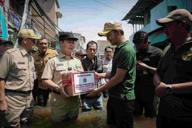 Pj Gubernur DKI Jakarta Teguh Setyabudi bersama Sekda DKI Jakarta Marullah Matali saat menyalurkan bantuan berupa bahan pokok kepada warga terdampak banjir rob di Kawasan Muara Angke, Kecamatan Penjaringan, Jakarta Utara, Senin (18/11/2024). 