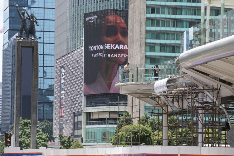 Pengunjung berfoto di anjungan Halte Transjakarta Bundaran Hotel Indonesia, Jakarta, Jumat (28/10/2022). Warga Ibu Kota datang ke halte yang belum sepenuhnya rampung itu untuk antre berfoto demi dapat latar belakang Patung Selamat Datang.