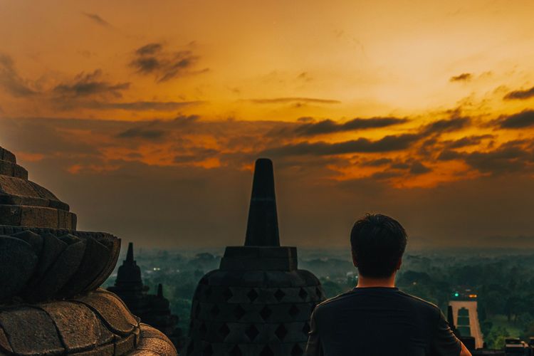 Ilustrasi melihat pemandangan matahari terbit dari puncak Candi Borobudur.