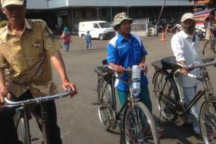 Tiga pengojek sepeda ontel menunggu calon penumpang keluar dari Stasiun Jakarta Kota, Jumat (11/9/2015).