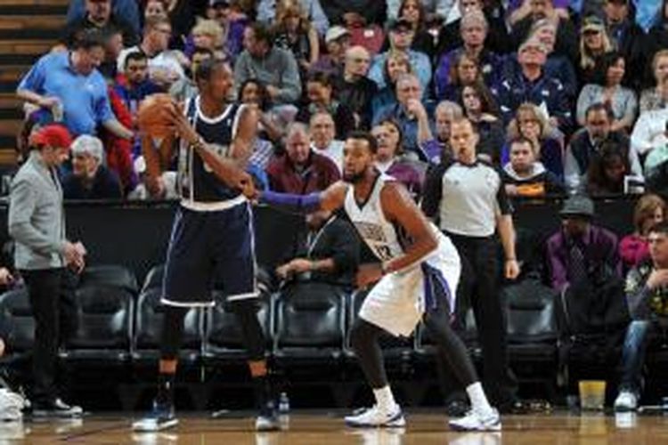 Pebasket Oklahoma City Thunder, Kevin Durant (kiri) berhadapan dengan Derrick Williams dari Sacramento Kings, pada laga lanjutan NBA di Sleep Train Arena, Selasa (03/12/2013).