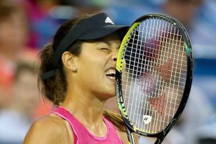 Petenis Serbia, Ana Ivanovic, menggigit raketnya setelah kehilangan poin ketika menghadapi petenis Rusia, Maria Sharapova, pada semifinal Western & Southern Open di Linder Family Tennis Center, Cincinnati, Sabtu (16/8/2014). Ivanovic menang 6-2, 5-7, 7-5.