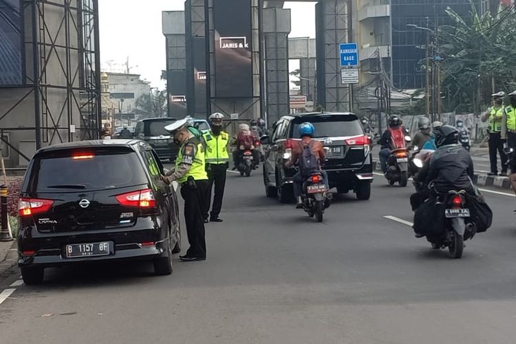 Polisi menilang sejumlah mobil yang melanggar aturan ganjil genap di Jalan RS Fatmawati, Cilandak, Jakarta Selatan pada Kamis (28/10/2021).